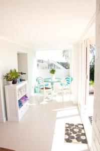 Habitación blanca con mesa y sillas. en The cashmere bothy, en Christchurch