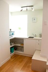 a kitchen with white cabinets and a sink in it at The cashmere bothy in Christchurch