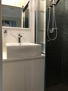 a bathroom with a sink and a shower at Mollymook Paradise Haven Motel in Mollymook