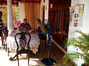 Ein Mann und eine Frau sitzen an einem Tisch in der Unterkunft Lakshmi Family Villa in Negombo