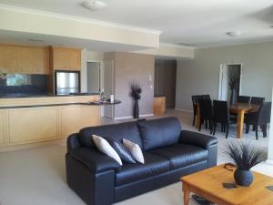 a living room with a couch and a kitchen at Boardwalk By The Beach in Rockingham