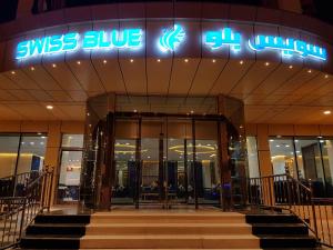 aiss blue sign on the front of a building at Swiss Blue Hotel Al Zahra in Jeddah
