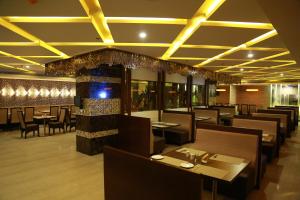 a dining room with tables and chairs and lights at Hotel SVM Grand Medipally in Upal