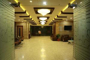 a lobby with couches and chairs in a building at Hotel SVM Grand Medipally in Upal