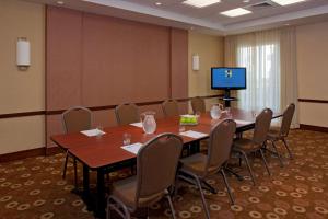 uma sala de conferências com uma mesa e cadeiras e uma televisão em Hyatt Place North Charleston em Charleston