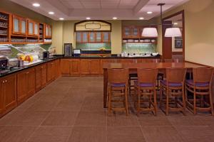eine große Küche mit einer großen Holzterrasse mit Barhockern in der Unterkunft Hyatt Place North Charleston in Charleston + 30 Fotos