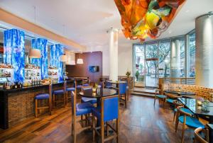 un restaurant avec des tables et des chaises bleues ainsi qu'un bar dans l'établissement Hyatt Place Portland-Old Port, à Portland