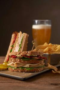 un sándwich en un plato junto a un vaso de cerveza en Hyatt Place Pensacola Airport en Pensacola