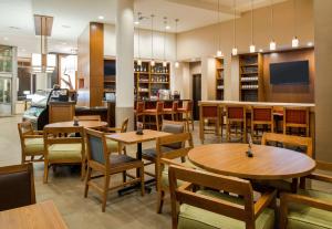 uma sala de jantar com mesas e cadeiras de madeira em Hyatt Place Portland-Old Port em Portland