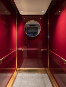 a small room with red walls and a mirror at The Fleming Hong Kong in Hong Kong