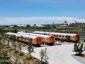 東港的住宿－大益火車民宿，停在停车场的一群橙色和白色火车
