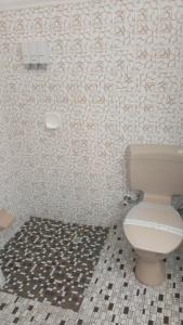 
a white toilet sitting next to a tile floor at Lindy Lodge Motel in Adelaide
