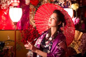 豐岡的住宿－城崎溫泉花小路彩月日式旅館，女人拿着红伞