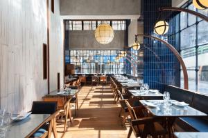 una sala da pranzo con tavoli, sedie e finestre di The Fleming Hong Kong a Hong Kong