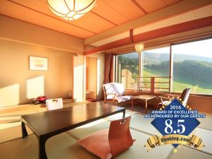 een woonkamer met een tafel en een groot raam bij Zao Kokusai Hotel in Zao Onsen