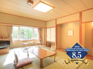 ein Wohnzimmer mit einem Tisch und Stühlen in der Unterkunft Zao Kokusai Hotel in Zao Onsen