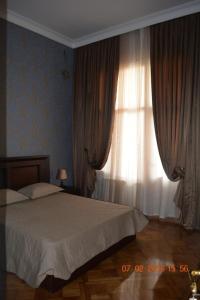 a bedroom with a bed and a window with curtains at Apartment Abdulkerim Ali-Zadeh 6 in Baku