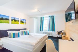 Habitación de hotel con cama y silla en DIE KRONE - Hotel Garni en Kirchzarten
