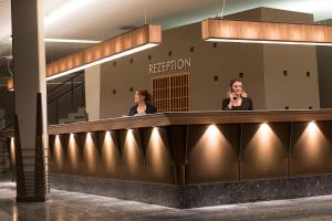 two women standing at a reception counter in a building at Excelsior Hotel Nürnberg Fürth, a member of Radisson Individuals in Fürth