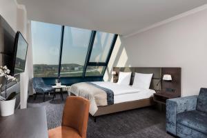 a hotel room with a bed and a chair at Excelsior Hotel Nürnberg Fürth, a member of Radisson Individuals in Fürth +47 photos