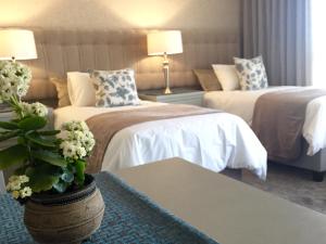 a hotel room with two beds and a table at Se La Vie Guest Suite in Big Bay