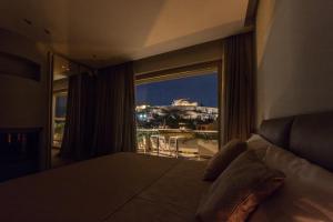 a bedroom with a large window with a view of a city at Unique Acropolis View in Athens