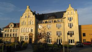 a large yellow building with a tower at Bohemica Apartments in Děčín