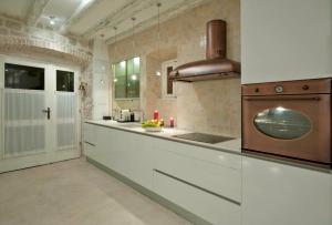 a kitchen with white cabinets and a sink at Apartment Whooart in Komiža