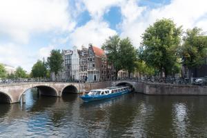 un barco que viaja por un río bajo un puente en Way Up Studio en Ámsterdam