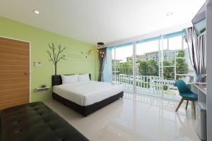 1 dormitorio con cama y ventana grande en Slowlife Beach, en Nai Yang Beach