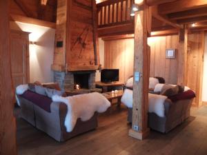 a living room with two couches and a fireplace at Le Roy des Montagnes à la Ferme des Ramus in Les Gets