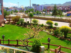 a park with a green lawn in a city at Dilshad Palace Hotel in Duhok