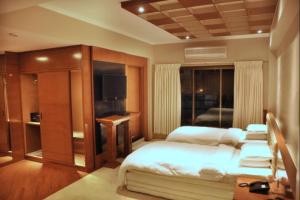 a bedroom with a bed and a television in it at Hotel Aram in Jamnagar