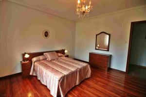 een slaapkamer met een bed en een spiegel bij Apart. As Redondas in Cabana de Bergantiños