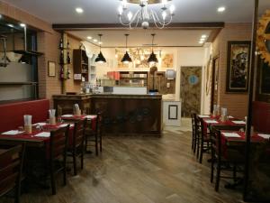 a dining room with tables and chairs and a kitchen at Residence Eleonora in Sottomarina