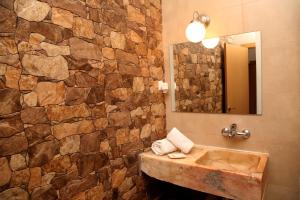 a bathroom with a sink and a stone wall at Terraços de Elvas I in Elvas
