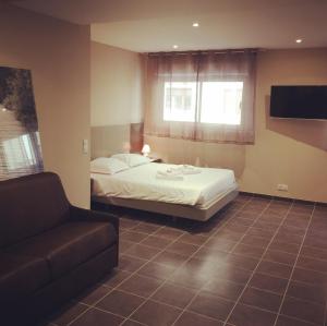 a hotel room with a bed and a couch at Villa Serafina Apartements in Nice