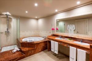 a bathroom with two sinks and a tub and a large mirror at Barceló Marbella in Marbella