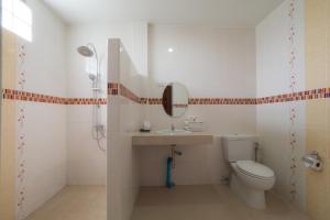 a bathroom with a toilet and a sink and a mirror at A Nice Resort in Buriram