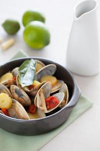 un bac rempli de palourdes et de légumes sur une table dans l'établissement Hotel Emporda, à Figueres