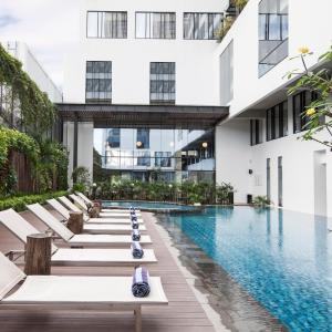 uma piscina num edifício com espreguiçadeiras em GAIA Cosmo Hotel em Yogyakarta