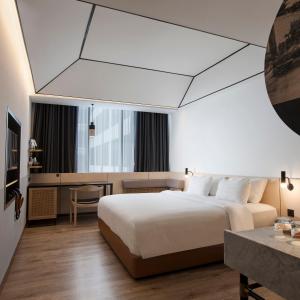 Postel nebo postele na pokoji v ubytování GAIA Cosmo Hotel