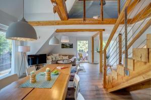 a living room and dining room with a wooden table and chairs at Spreewaldferienhaus - Urlaub in Lübben