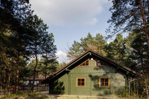 ein grünes Haus mitten im Wald in der Unterkunft Domizil Katharina in Borkwalde