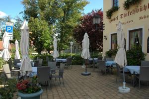 un restaurante con mesas, sillas y sombrillas en Dinkelsbühler Hof, en Dinkelsbühl