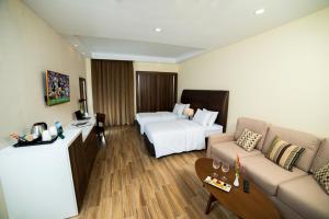 アルビールにあるMasaya By Emeraldのベッドとソファ付きのホテルルーム