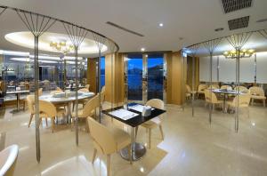 uma sala de jantar com mesas, cadeiras e janelas em The Crystal Resort Sun Moon Lake em Yuchi