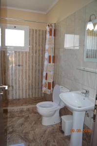 a bathroom with a toilet and a sink at Garden View Apartments in Anaxos
