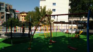 um parque infantil vazio com um baloiço num parque em Hotel Park 1 em Kiten