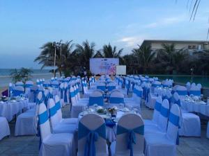 banquete con mesas y sillas azules y blancas en Villa Del Sol Beach Resort & Spa, en Phan Thiet